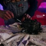 Mechanik naprawiający instalację elektryczną w klasycznym aucie w garażu