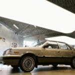 Zabytkowy samochód w nowoczesnej, przeszklonej hali wystawowej