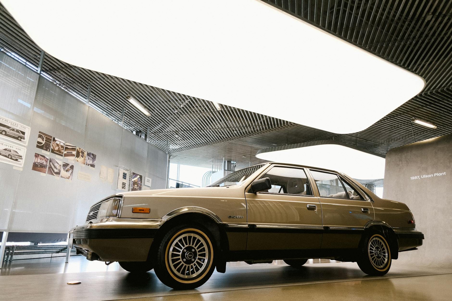 Zabytkowy samochód w nowoczesnej, przeszklonej hali wystawowej