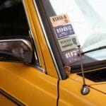 Zbliżenie żółtego klasycznego auta z naklejkami retro na szybie