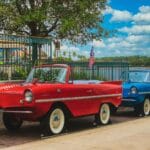 Czerwone i niebieskie amfibie retro zaparkowane nad jeziorem