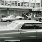 Laweta z klasycznymi autami na miejskiej ulicy w czerni i bieli