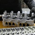 Mechanik montuje głowicę silnika na stole warsztatowym