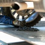Mechanik zapina auto łańcuchem na platformie przed holowaniem
