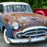 Zardzewiały klasyczny Packard zaparkowany na zewnątrz w mieście