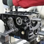 Zbliżenie na montaż silnika spalinowego z widocznymi metalowymi częściami