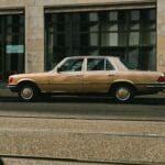 Złoty zabytkowy Mercedes zaparkowany przy ulicy w mieście