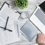 Formularze ubezpieczeniowe i laptop na biurku w biurze