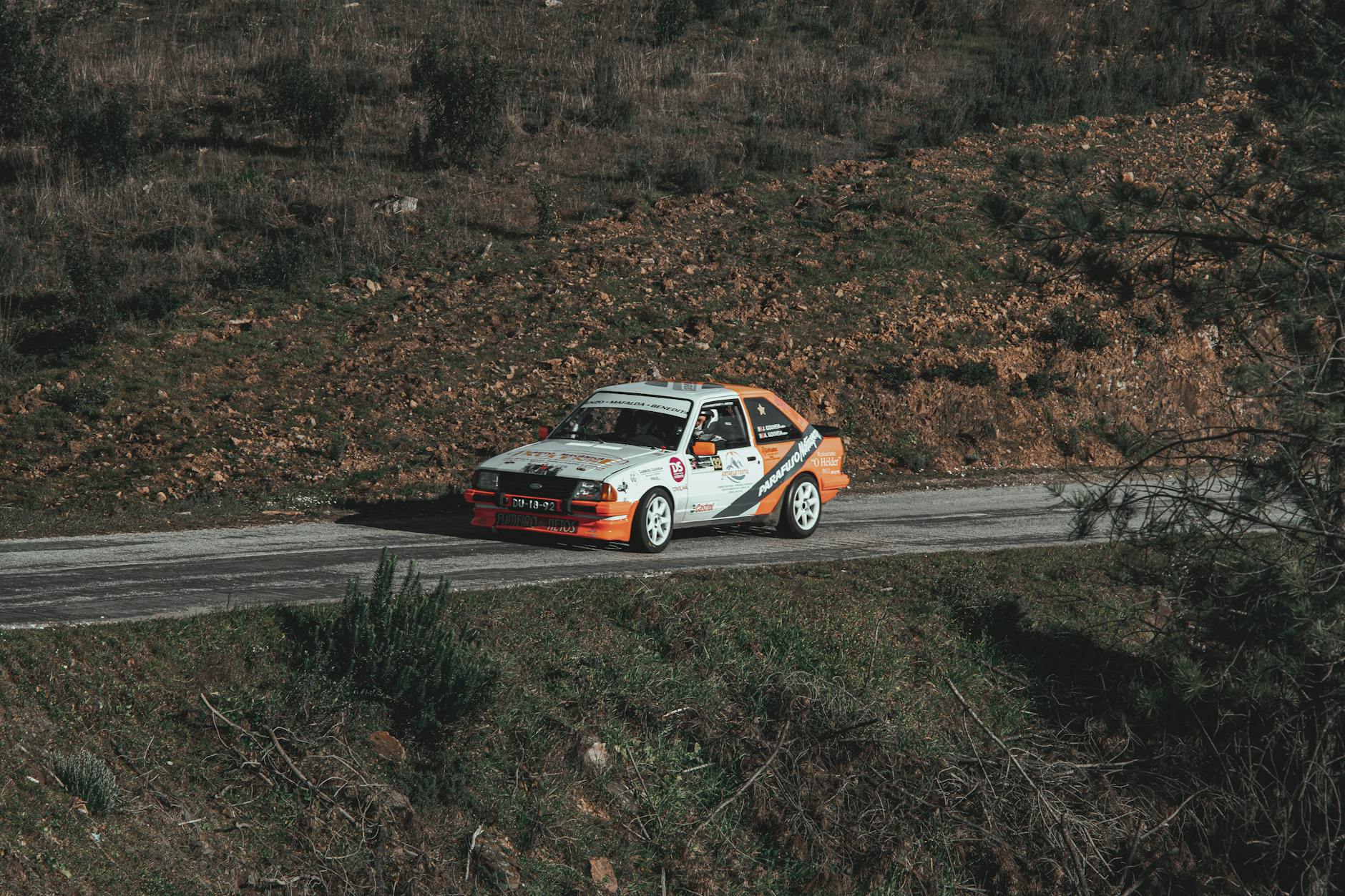 Klasyczne rajdowe auto pędzi przez polską wieś podczas wyścigu