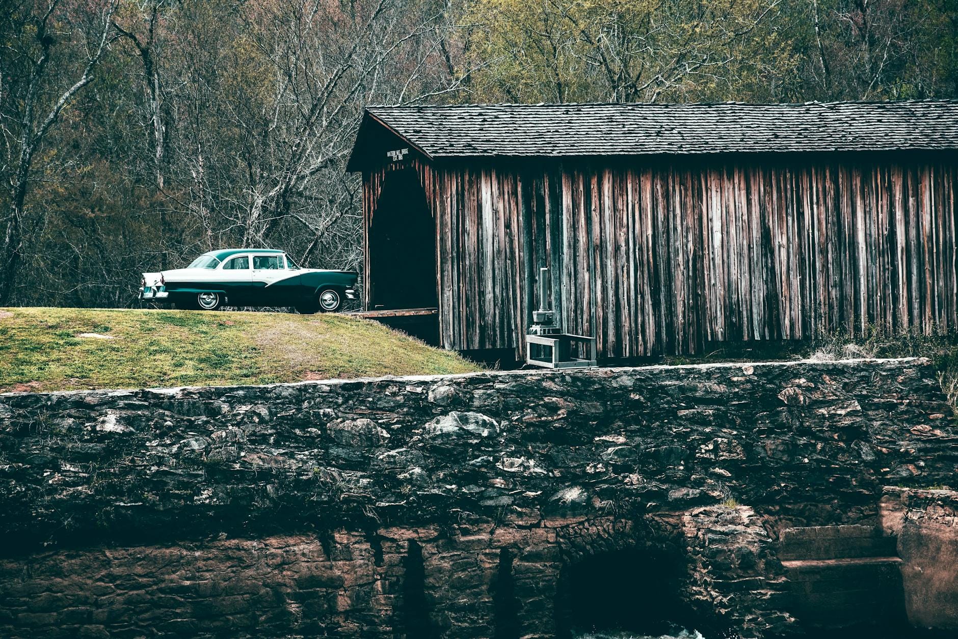 Klasyczny Ford Fairlane zaparkowany przy drewnianej stodole na wsi