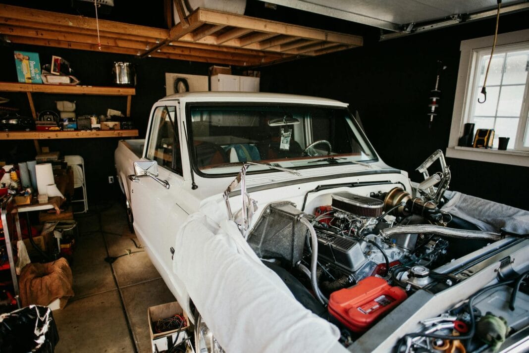 Mechanik naprawia silnik klasycznego pickupa w przydomowym garażu