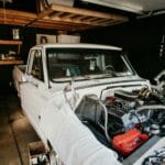 Mechanik naprawia silnik klasycznego pickupa w przydomowym garażu