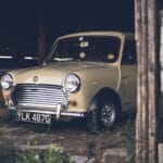 Zabytkowe auto zaparkowane na ziemi w drewnianej stodole
