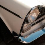 Jak pogodzić pełną renowację nadwozia z zachowaniem oryginalnych śladów eksploatacji Zbliżenie chromowanego grilla i reflektora zabytkowego samochodu