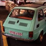Miętowy Fiat 500 zaparkowany w hali, klasyczny zagraniczny mikrus