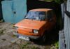 Pomarańczowy Fiat 126p zaparkowany na podwórku w Poznaniu