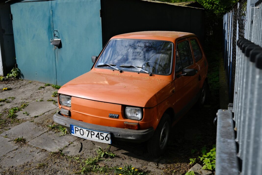 Pomarańczowy Fiat 126p zaparkowany na podwórku w Poznaniu