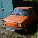 Pomarańczowy Fiat 126p zaparkowany na podwórku w Poznaniu